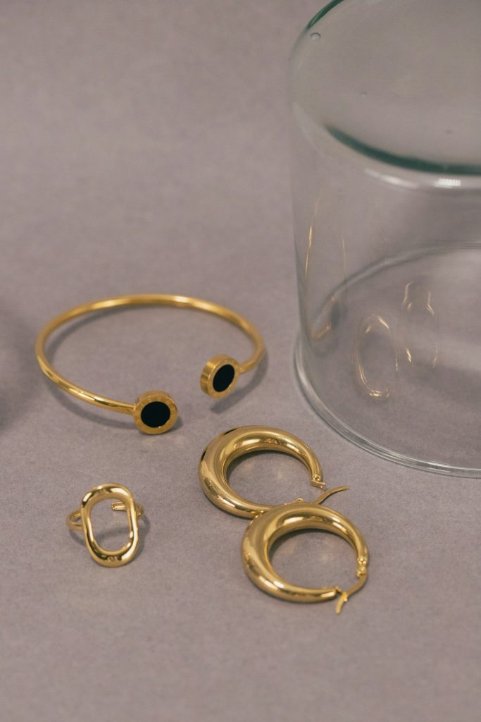 a-pair-of-gold-rings-and-a-glass-of-water-9yyrvf3s7ls