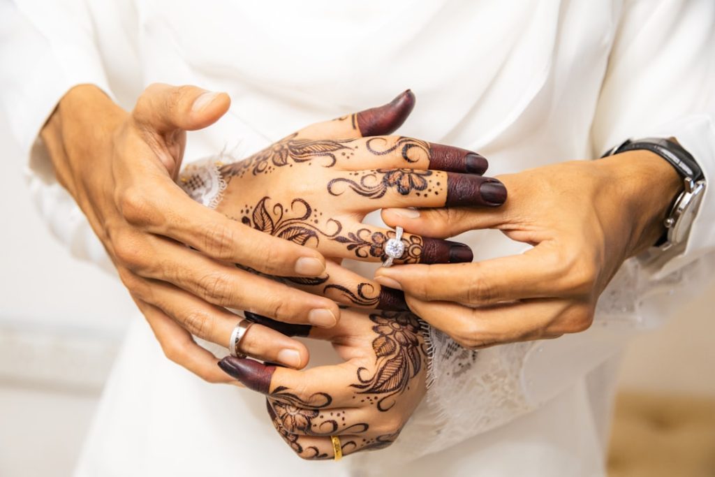 hands-exchanging-wedding-rings-with-henna-designs-7pbuf9zb0ga