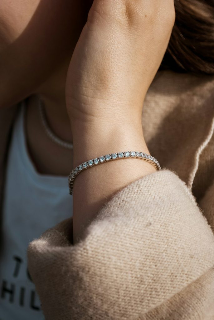 Ragazza con bracciale tennis in argento e cristalli bianchi fotografata in un giorno dautunno.